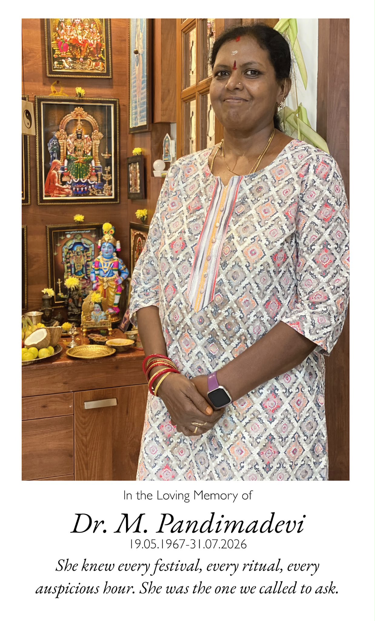 Amma standing beside her home puja shrine. She knew every festival, every ritual, every auspicious hour. She was the one we called to ask.