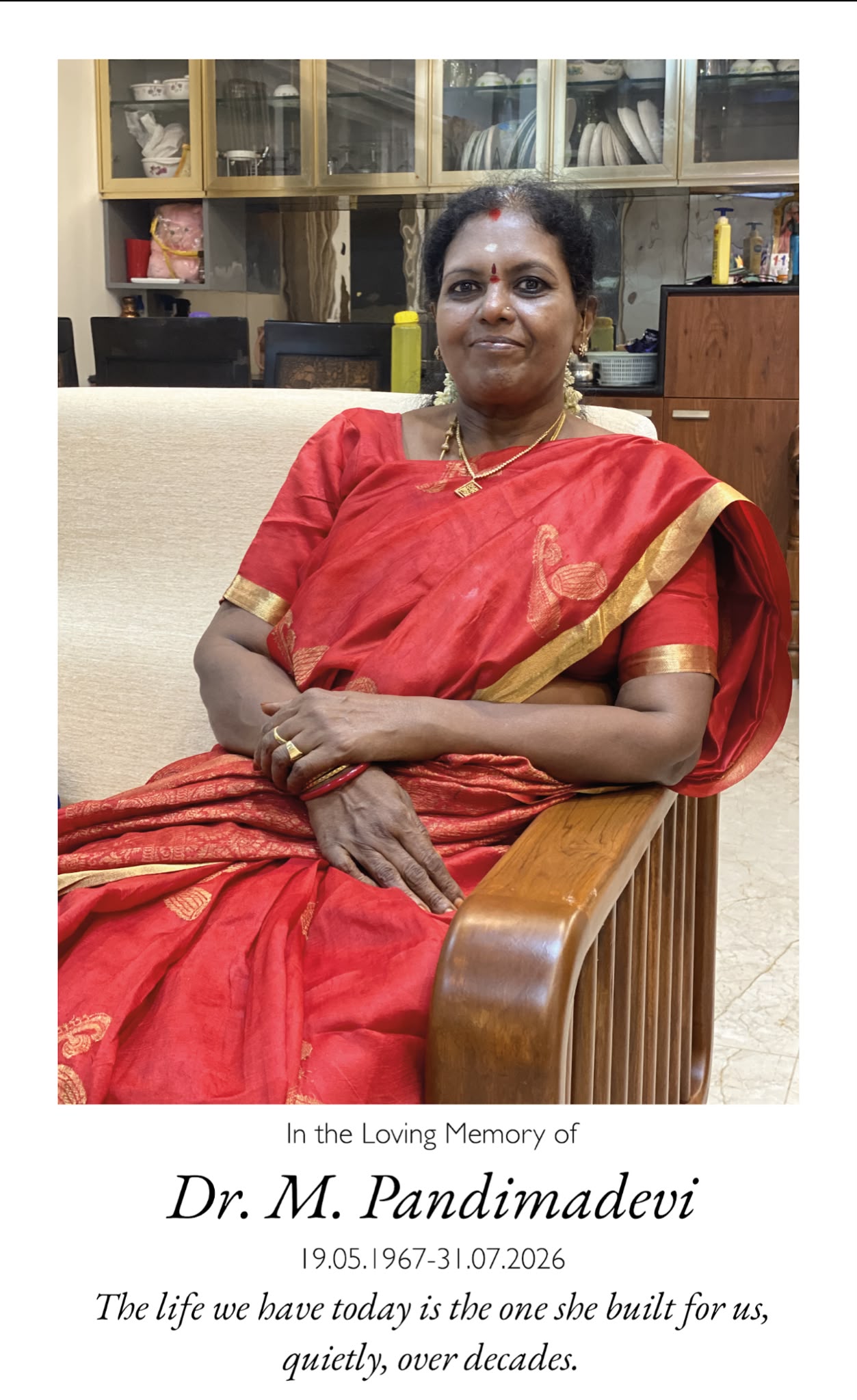 Amma seated in a red silk saree at home. The life we have today is the one she built for us, quietly, over decades.
